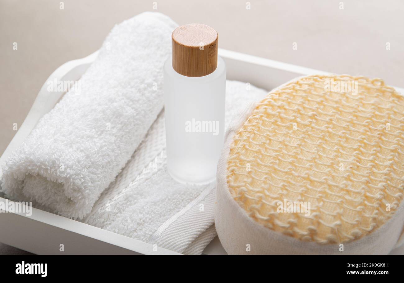 Concetto di gel di lavaggio intimo per l'igiene quotidiana della delicata zona intima. Bottiglia di sapone opaco con gel su asciugamano bianco arrotolato e spugna da bagno a casa. Foto Stock