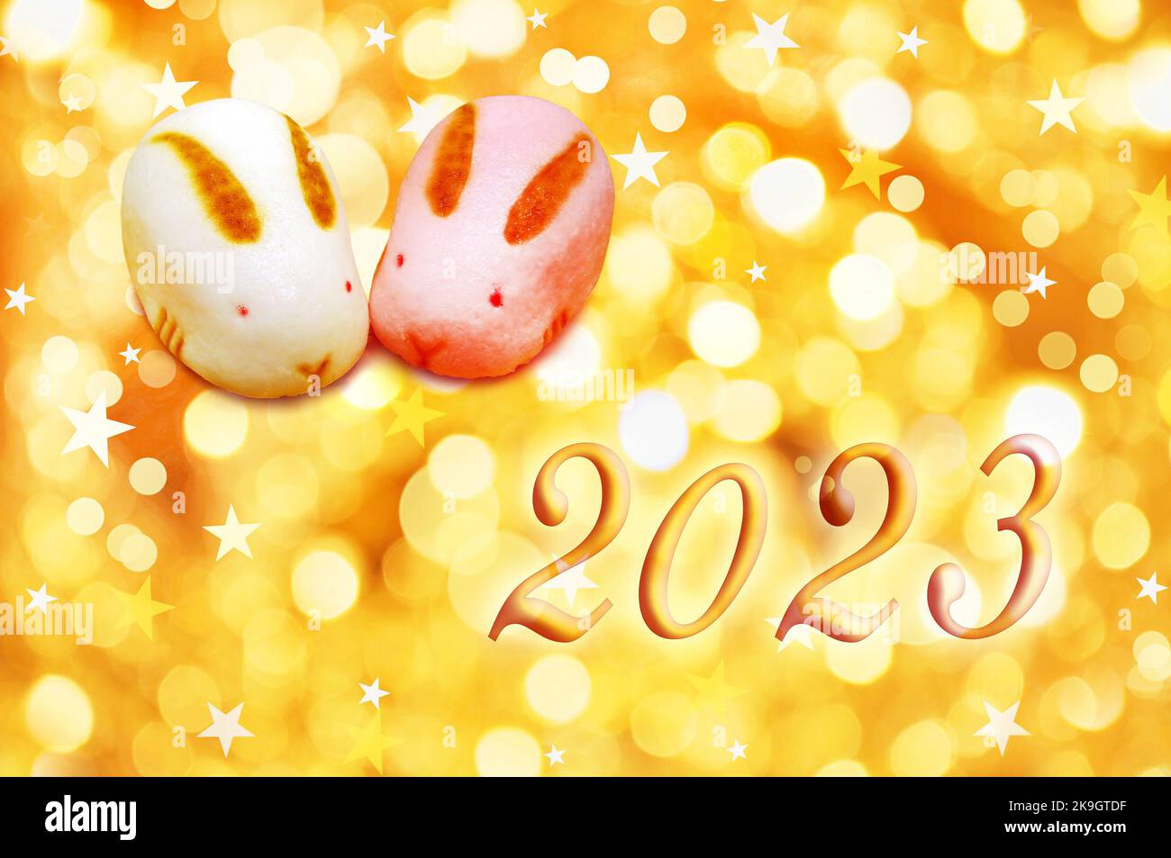 2023, anno del coniglio. Biglietto d'auguri giapponese con dolci a forma di coniglio e luci dorate per le feste Foto Stock