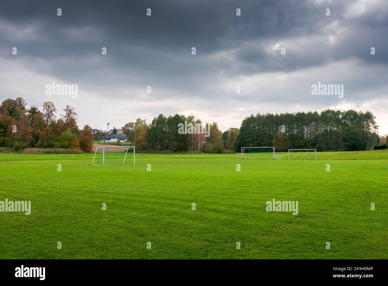 Un campo di allenamento di calcio in un paesaggio rurale autunnale. Erba lussureggiante perfettamente rifinita. Un campo da calcio situato in una splendida posizione. Polanka W Foto Stock