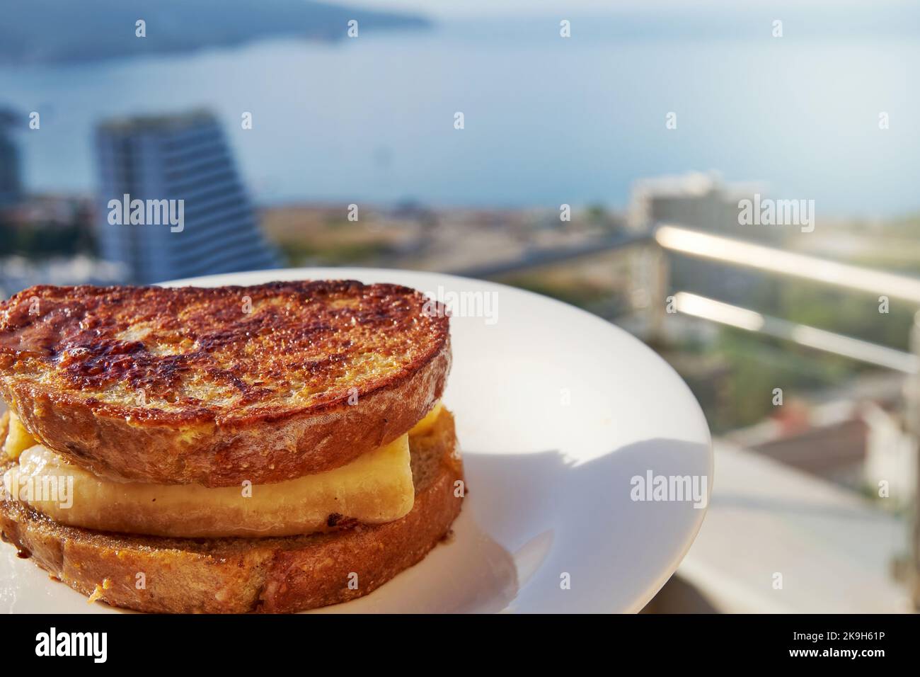Pane tostato alla griglia con banana e cannella sulla terrazza di un hotel sul mare. Vacanze di viaggio e vacanze estive Foto Stock