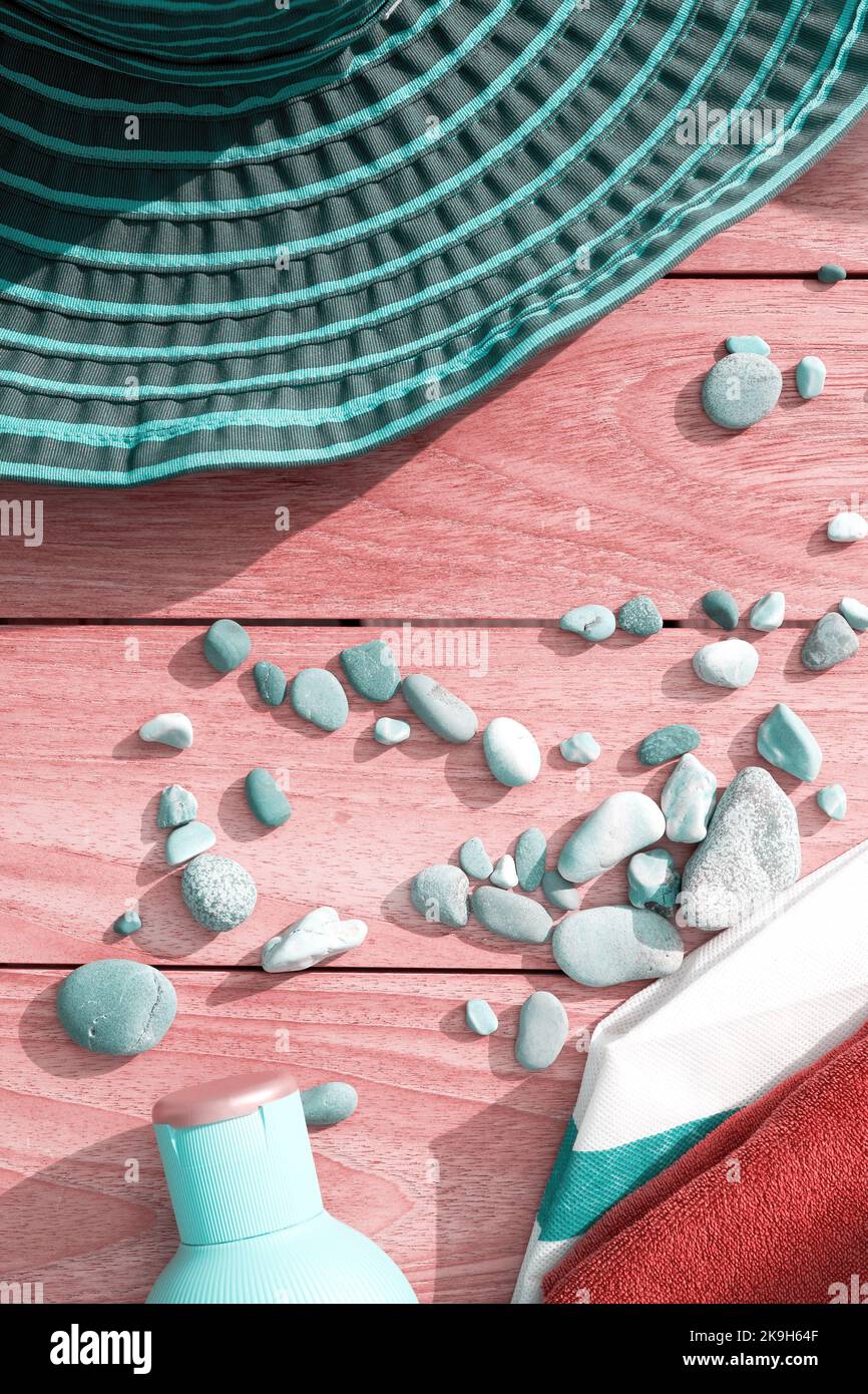 Immagine verticale con cappello turchese, creme e ciottoli sulla terrazza. Tema delle vacanze estive Foto Stock