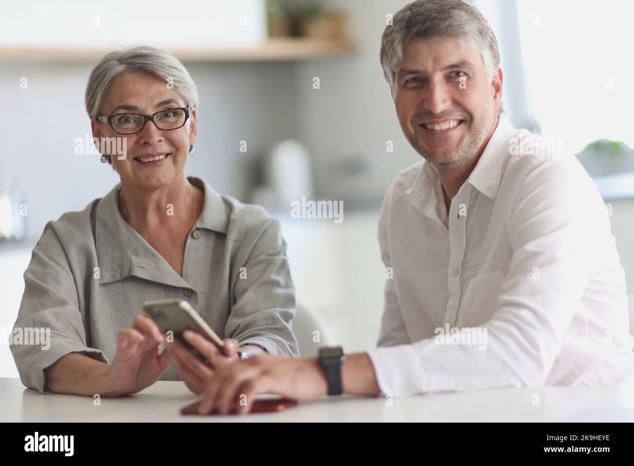 donna d'affari e uomo d'affari sorridenti seduti al tavolo. Foto Stock