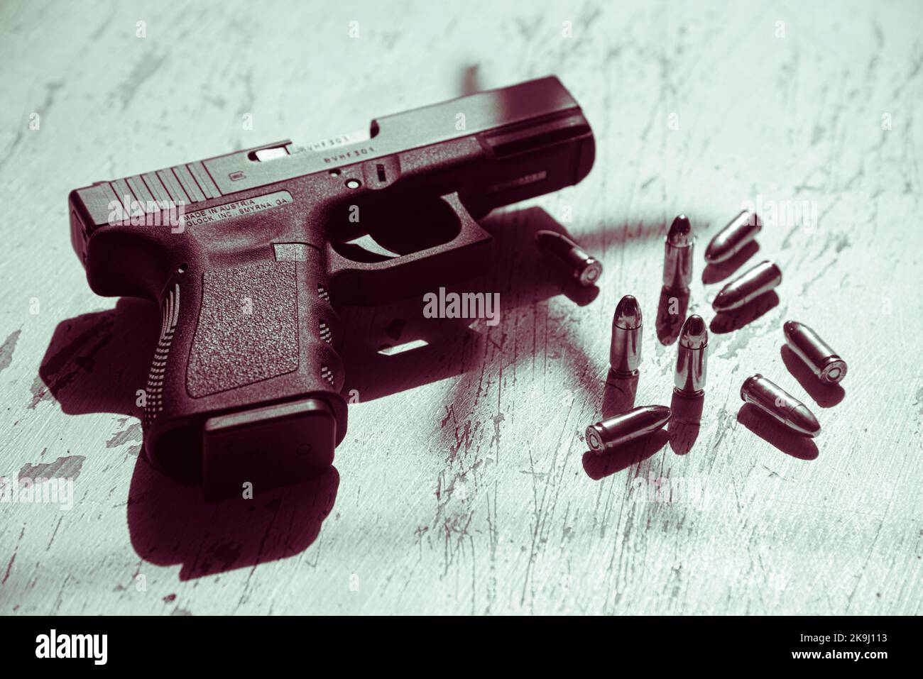 Una pistola Glock 19, prodotta in Austria, si trova su un tavolo insieme a diverse cartucce di munizioni 9mm. Foto Stock