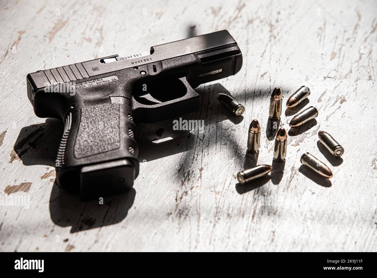Una pistola Glock 19, prodotta in Austria, si trova su un tavolo insieme a diverse cartucce di munizioni 9mm. Foto Stock
