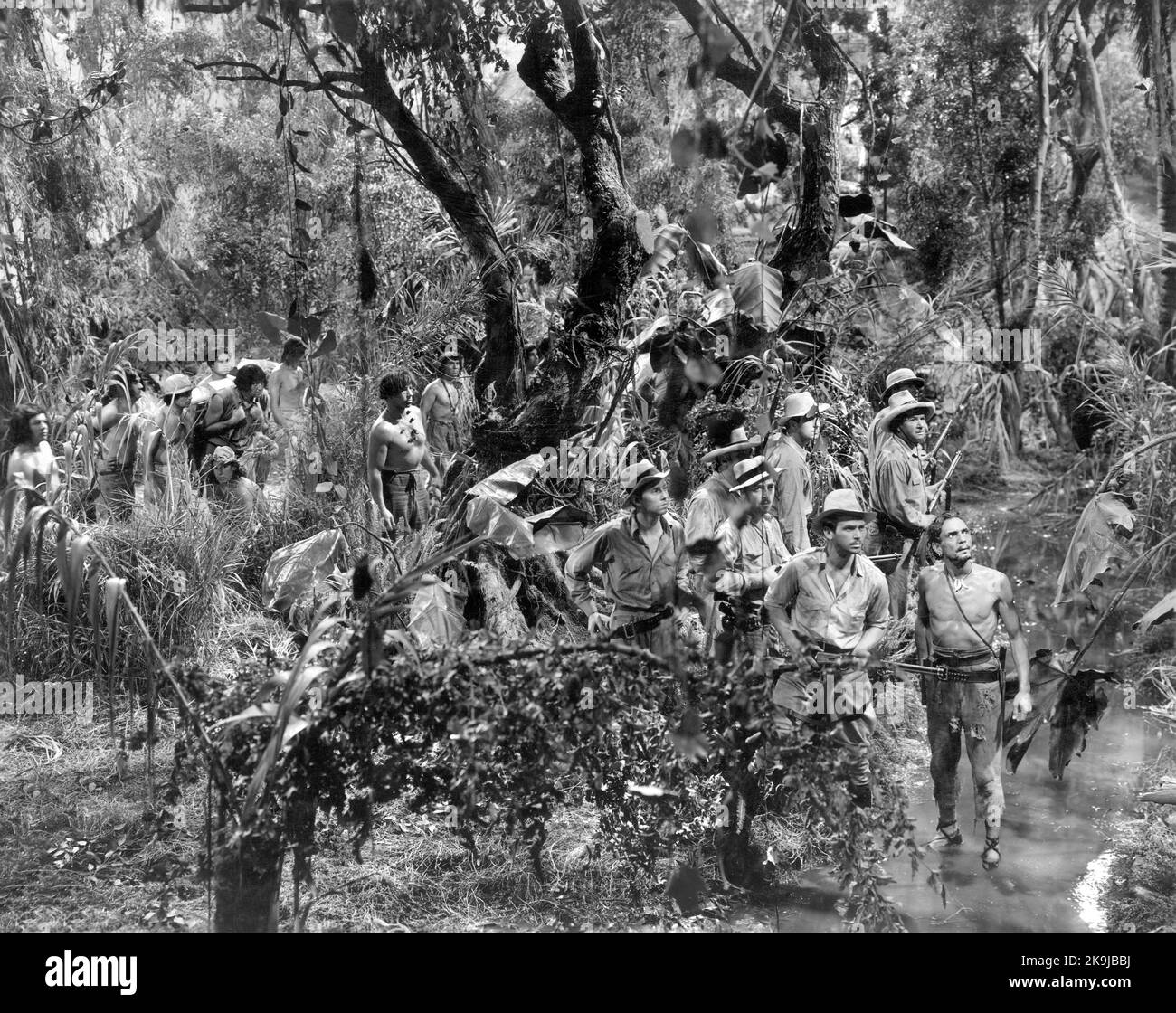 Douglas Fairbanks, Jr. (Fucile in mano), Francis McDonald, gene Garrick, John Howard, Vincent Price, George Bancroft, on-set of the Film, 'Inferno Verde', Universal Pictures, 1940 Foto Stock