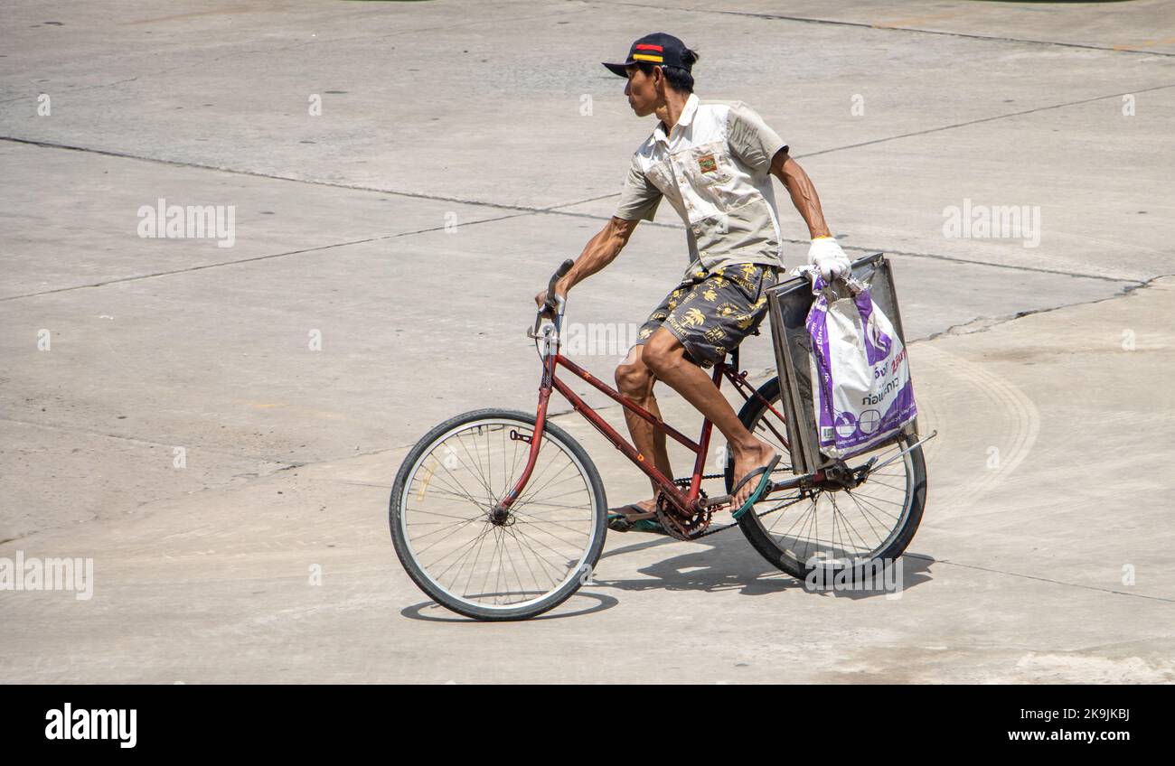 SAMUT PRAKAN, THAILANDIA, ottobre 04 2022, Un uomo guida una bicicletta e tiene un carico in una mano Foto Stock