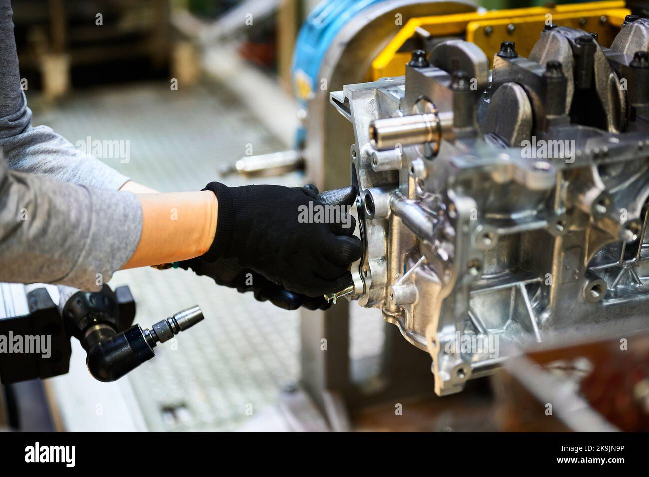 Assemblaggio del motore dell'auto a mano dell'operatore nel primo piano dell'officina Foto Stock