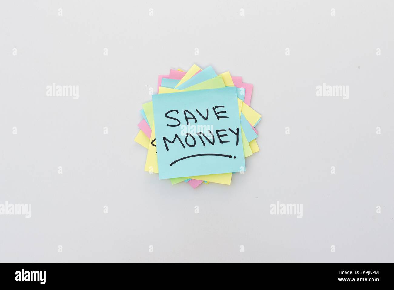 Risparmia denaro scritto a mano su un post-it con sfondo bianco isolato Foto Stock