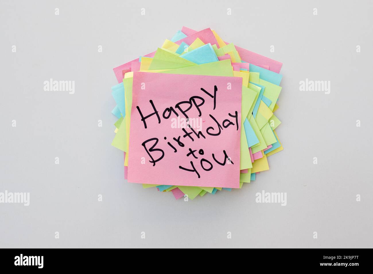 Buon compleanno a voi ha scritto a mano la nota su un blocco note appiccicoso Foto Stock