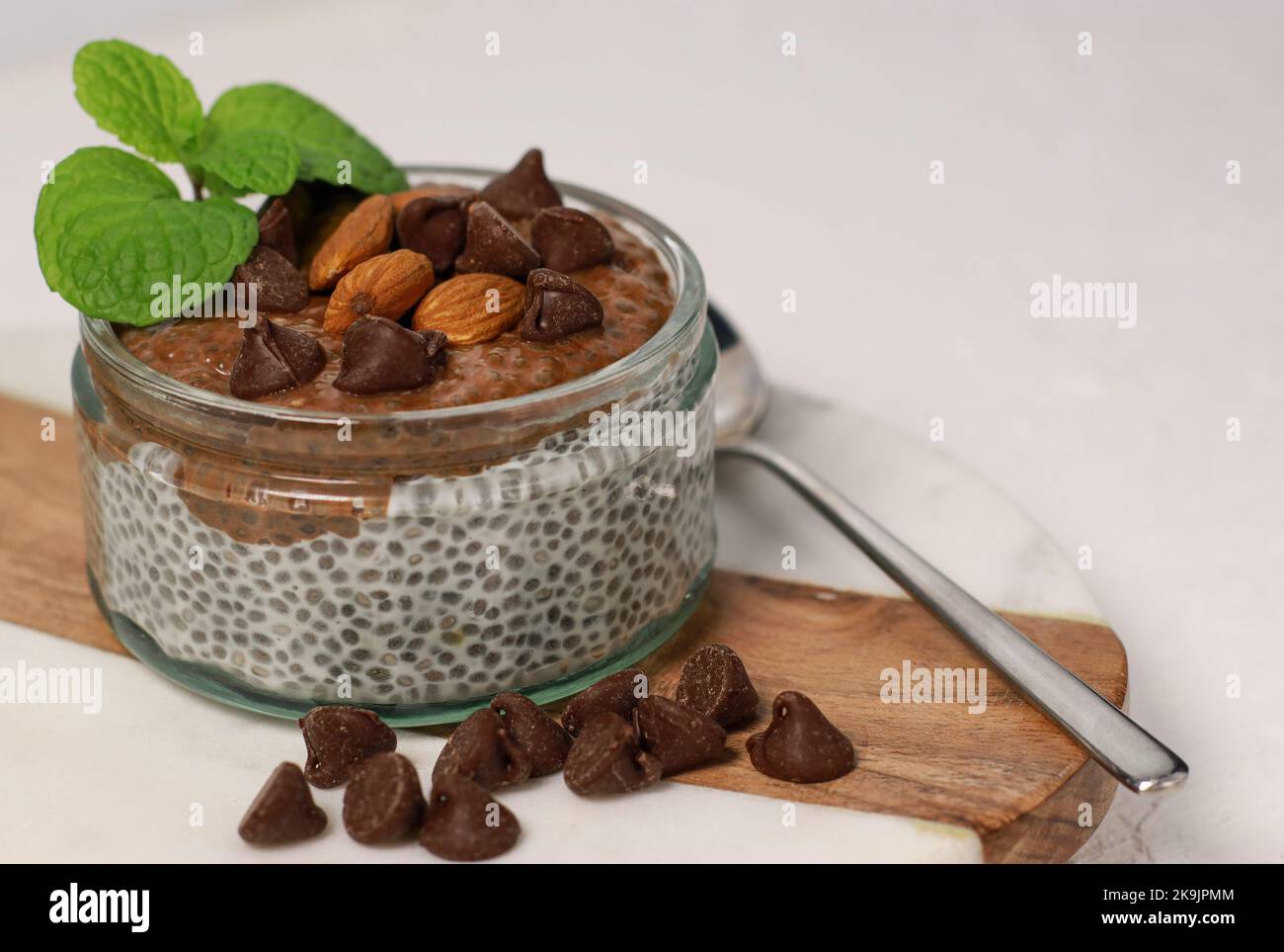 budino di chia con cioccolato e mandorle su tavolo bianco Foto Stock