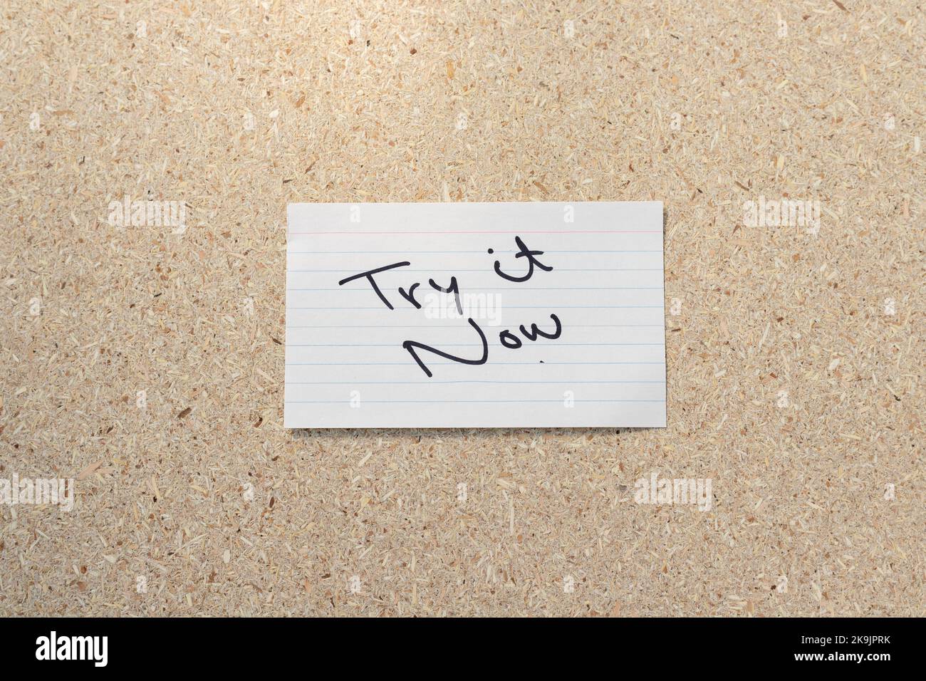 Provalo ora citazione motivazionale Nota appiccicosa scritta a mano sul fondo della tavola di sughero Foto Stock