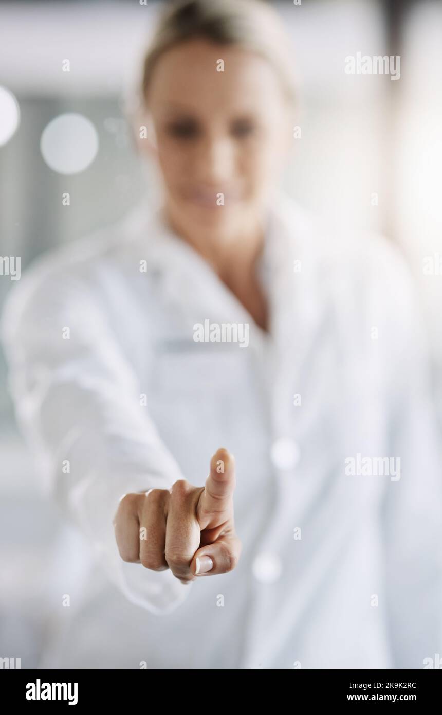 Utilizzo della tecnologia per i progressi scientifici. Una scienziata matura che lavora sulla tecnologia touchscreen mentre fa ricerche nel suo laboratorio. Foto Stock