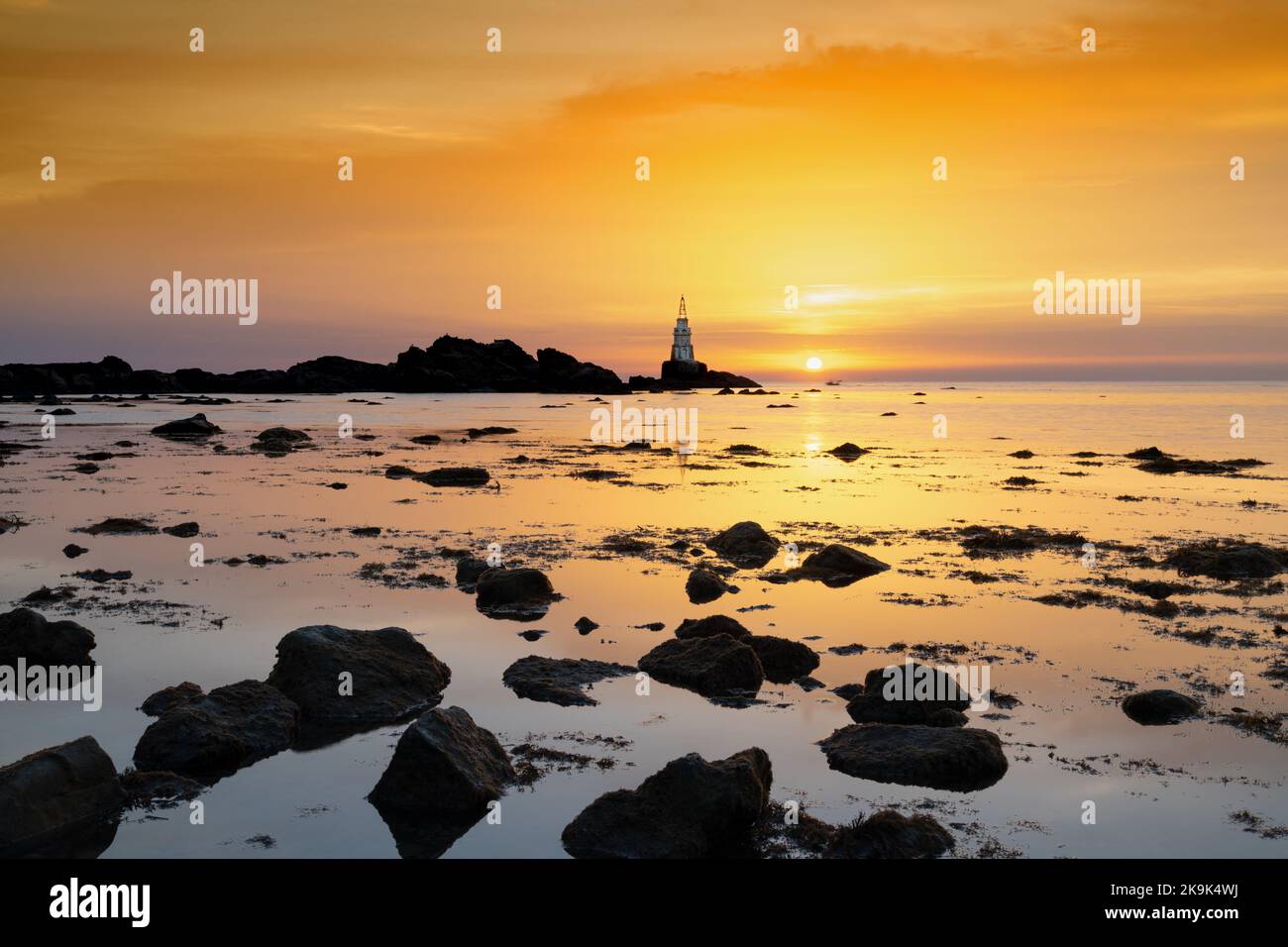 Paesaggio di alba sulla costa bulgara del Mar Nero ad Athopol con il faro del porto e la costa rocciosa Foto Stock