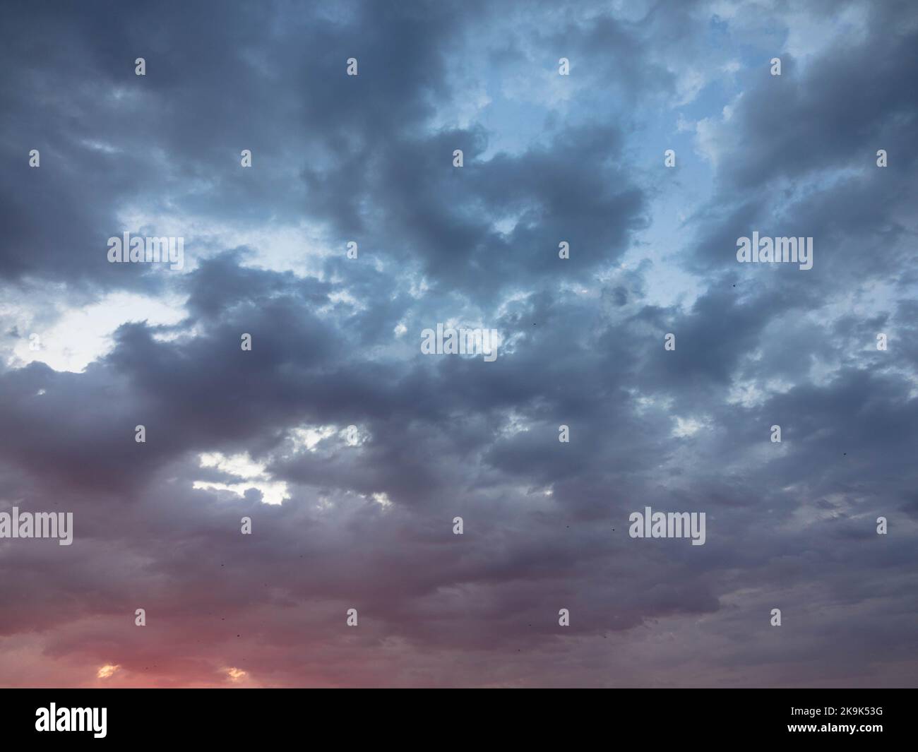 Spettacolare cielo crepuscolo e sfondo nuvoloso. Cielo naturale viola scuro. Nuvole scure, tempesta e pioggia. Concetto di clima e natura. Molto spazio di testo. Foto Stock