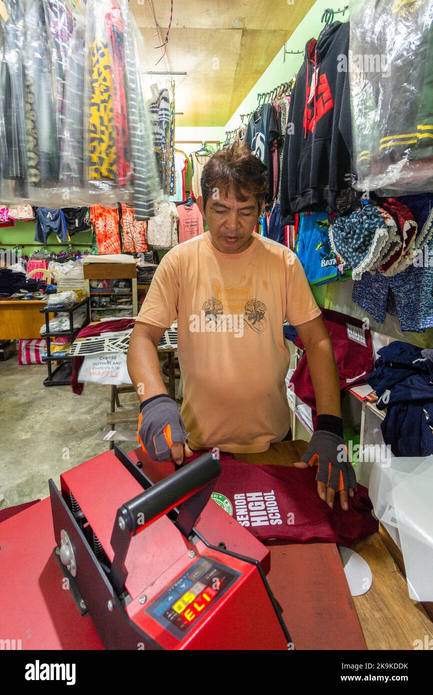 Un uomo filippino che stampa una camicia a Batangas, Filippine Foto Stock