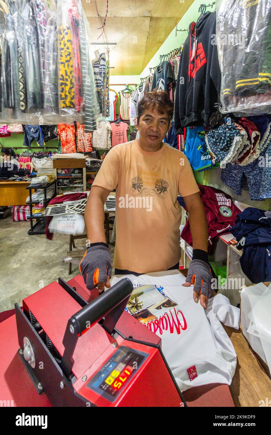 Un uomo filippino che stampa una camicia a Batangas, Filippine Foto Stock