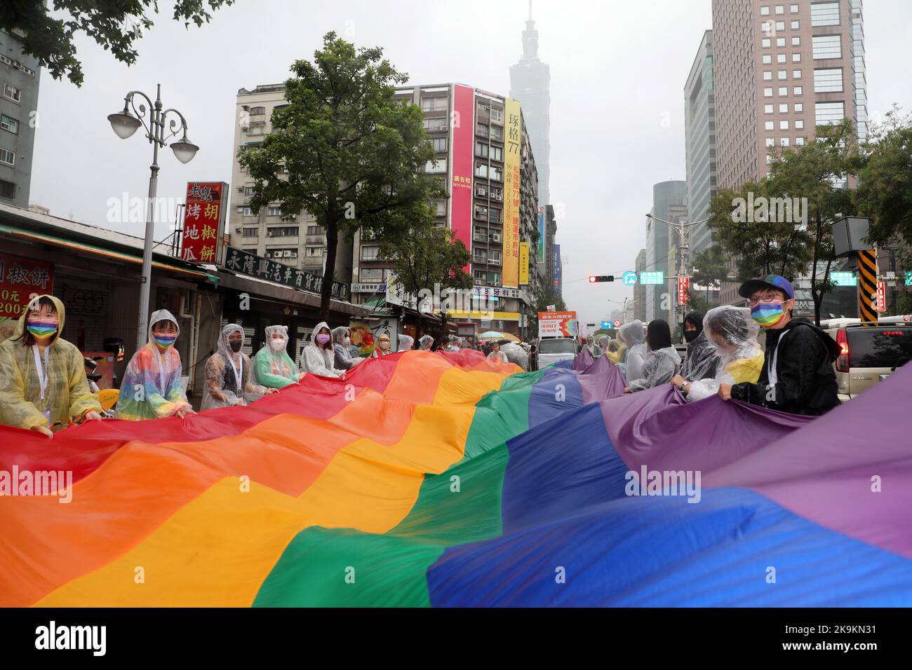 Taipei, Taiwan. 29th Ott 2022. La gigantesca bandiera arcobaleno nelle strade di Taipei alla Parata Pride LGBT di Taipei, Taipei, Taiwan. Il 20th° anniversario della sfilata si è svolto nonostante la pioggia e i partecipanti hanno sfidato gli elementi soprattutto con gli ombrelli, ma ciò non ha smorzato l'umore o il divertimento. Decine di migliaia di persone si sono unite alla parata che ha avuto luogo in un percorso tortuoso dal Municipio di Taipei all'ombra dell'edificio più alto di Taiwan, Taipei 101. Credit: Paul Brown/Alamy Live News Foto Stock