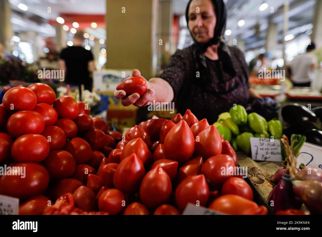 Bucarest, Romania - 4 agosto 2022: Profondità di campo poco profonda (fuoco selettivo) dettagli con una donna senior che vende ortaggi in uno stand nel mercato Obor Foto Stock