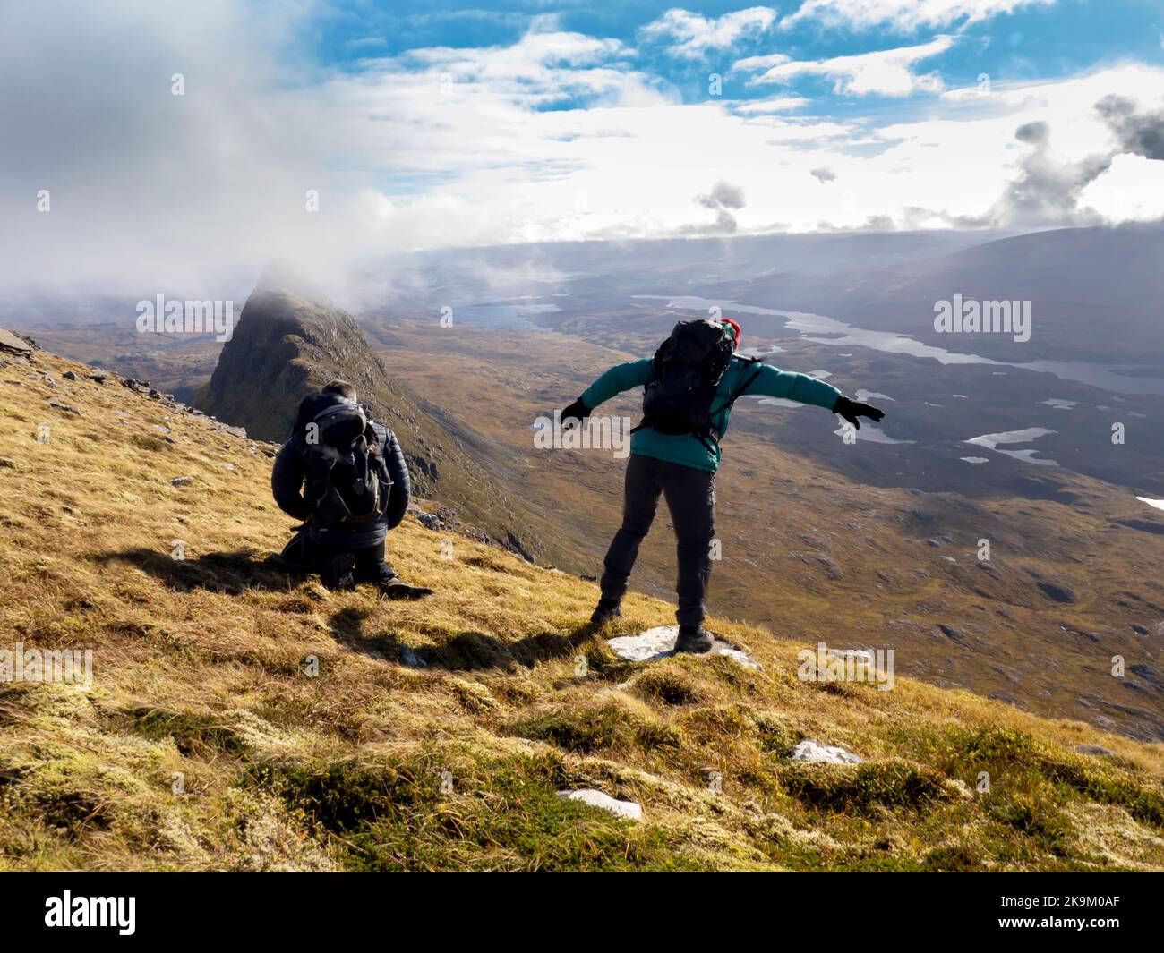 Gli escursionisti che vengono colpiti dalla forza delle galline si snodano su Suilven, Assynt, Scozia, Regno Unito. Foto Stock