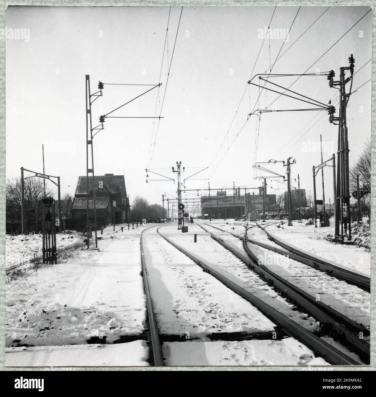Dietro l'incrocio ferroviario, la casa stazione intravede. Foto Stock