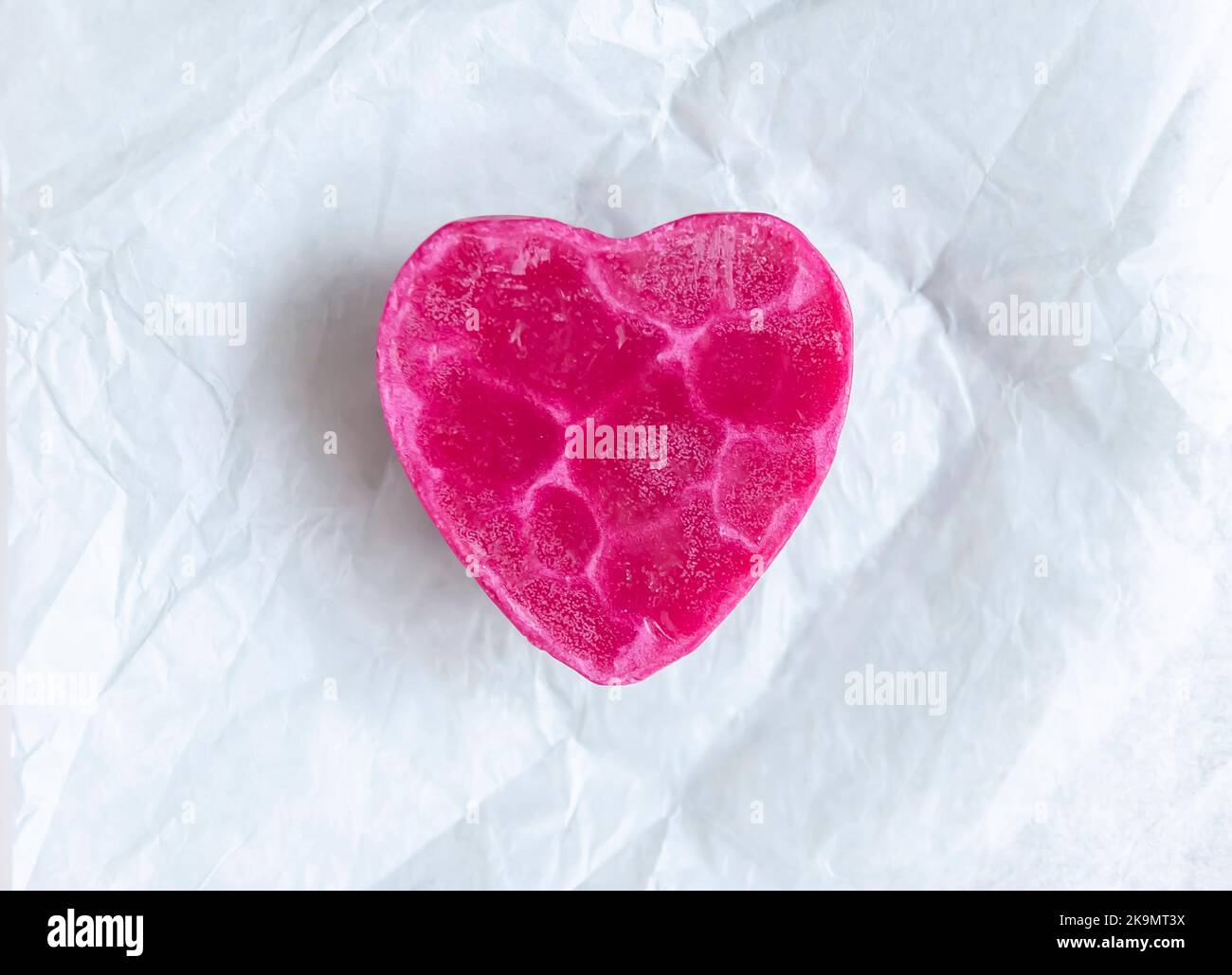 Saponetta a forma di cuore su sfondo morbido e chiaro. Vista dall'alto. Foto Stock