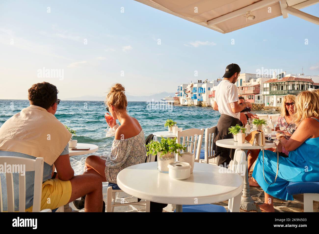 I turisti dell'isola di Mykonos nel bar sul lungomare Foto Stock