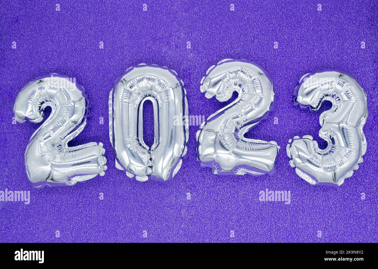 Numeri gonfiabili in argento lucido del nuovo anno 2023 su sfondo viola, molto peri. Spazio di copia. Foto Stock