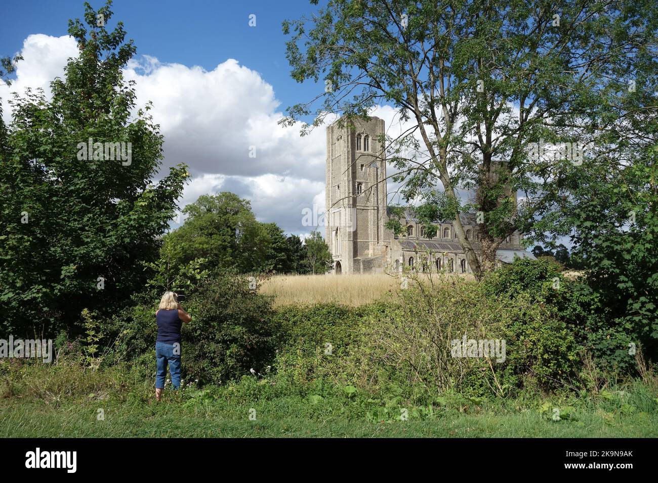 Donna che scatta una foto alla chiesa dell'abbazia di Wymondham, Norfolk Foto Stock