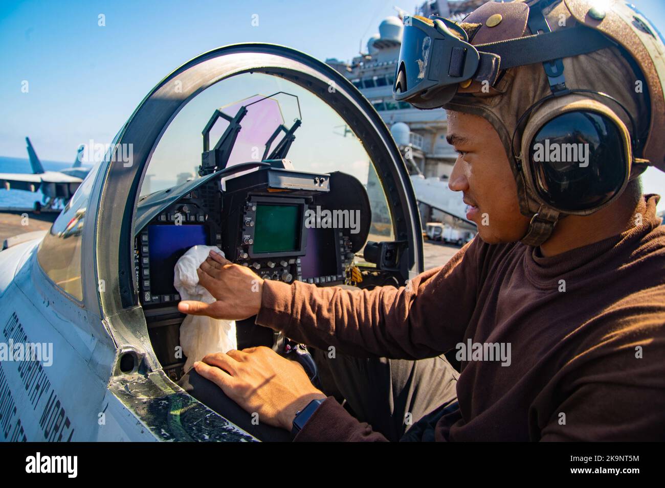 Airman Demintri Spencer, di New York, assegnato ai “Blue Blasters” di Strike Fighter Squadron (VFA) 34, pulisce l'abitacolo di un F/A-18E Super Hornet sul ponte di volo a bordo della portaerei di classe Nimitz USS Harry S. Truman (CVN 75) Foto Stock