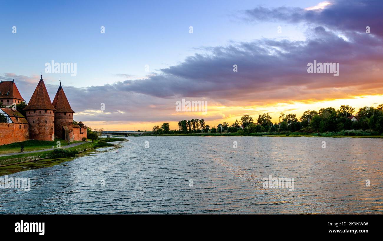 Malbork castello presso il fiume Nogat al tramonto, Polonia. Foto Stock