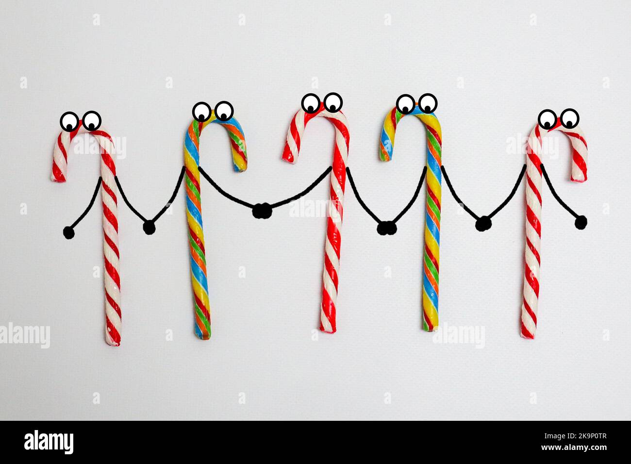 Lollipop di Natale e mani di mantenimento caramelle. Fumetti creativi caramelle di Natale. Buon natale Foto Stock