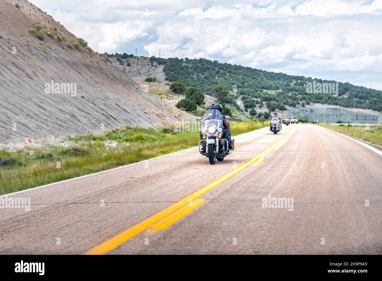 Lonetree, USA - 24 luglio 2019: Arido deserto paesaggio canyon nel Wyoming strada 414 con ciclisti su moto Harley Davidson Foto Stock