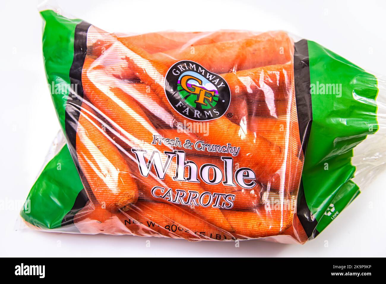 Napoli, USA - 21 ottobre 2021: Macro di primo piano di Grimmway fattorie marca intero crudo crudo crudo croccante di carote rosse arancioni in borsa su sfondo bianco Foto Stock