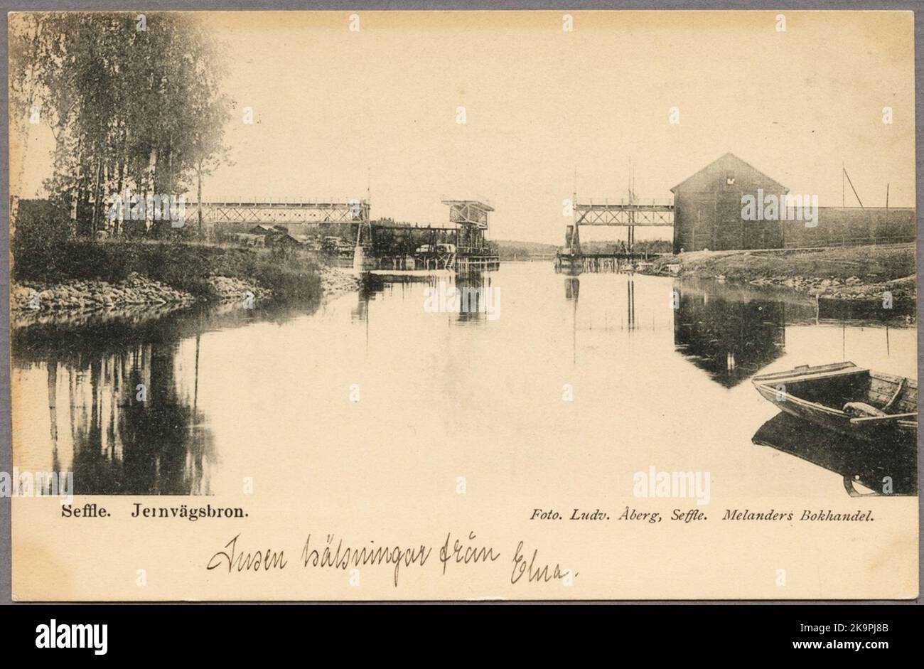 Vista sul fiume villaggio con ponte ferroviario sullo sfondo. Foto Stock