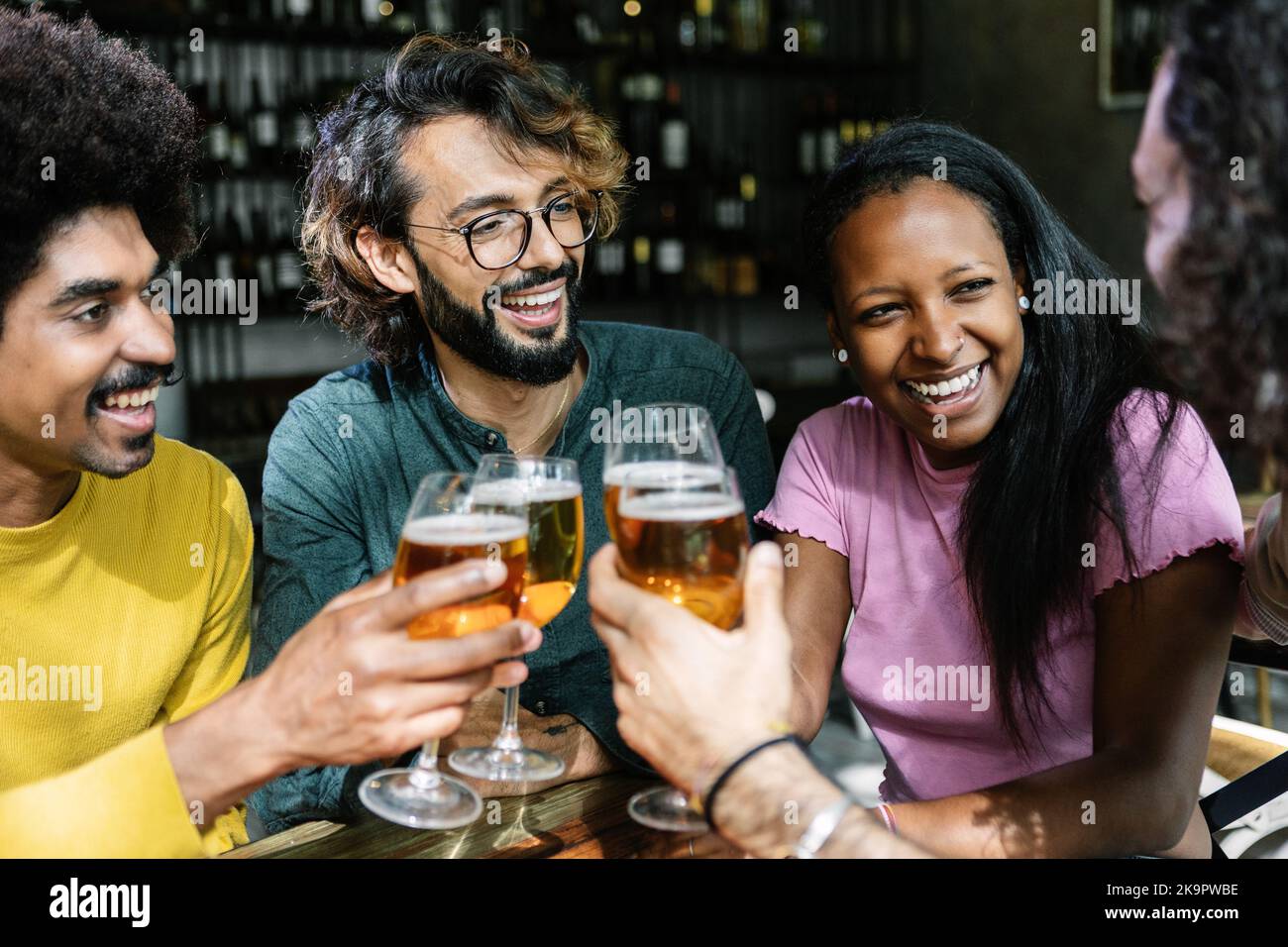 Gruppo di amici diversi che si godono il fine settimana insieme allietare con la birra al bar Foto Stock