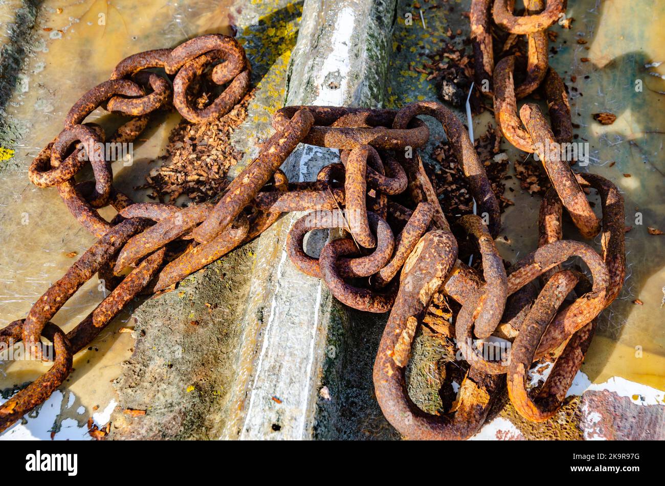 Una catena arrugginita che giace sul pavimento di Mudeford Quay a Dorset, Regno Unito Foto Stock