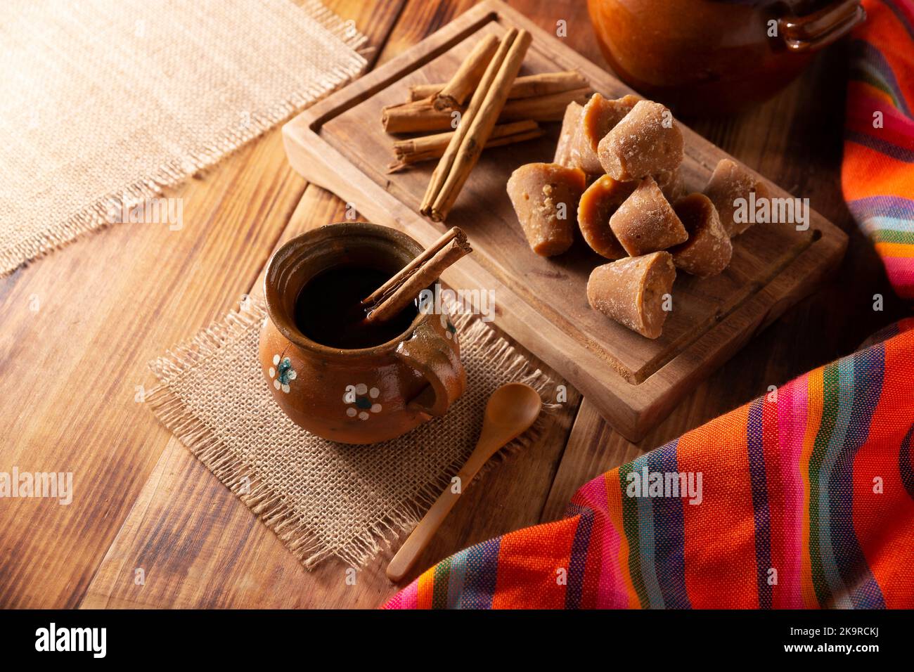 Autentico caffè messicano fatto in casa (cafe de olla) servito in tradizionale tazza di argilla fatta a mano (Jarrito de barro) su un rustico tavolo di legno. Foto Stock