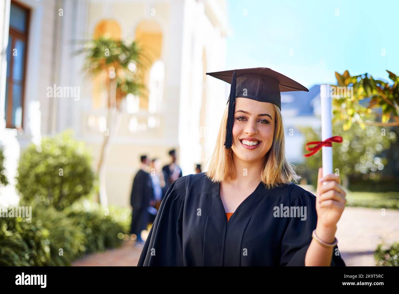 Ciò aumenterà le mie probabilità di successo. Una giovane donna felice che tiene il suo certificato il giorno della laurea. Foto Stock