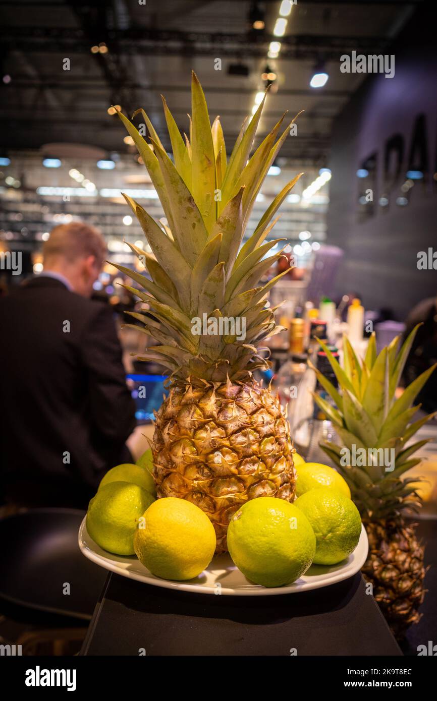 un ananas e limoni sono su un piatto su un bancone Foto Stock
