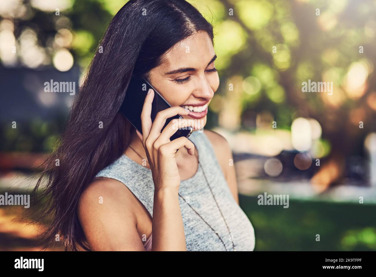 ID amore per incontrare. Una giovane donna attraente che parla su un cellulare all'aperto. Foto Stock