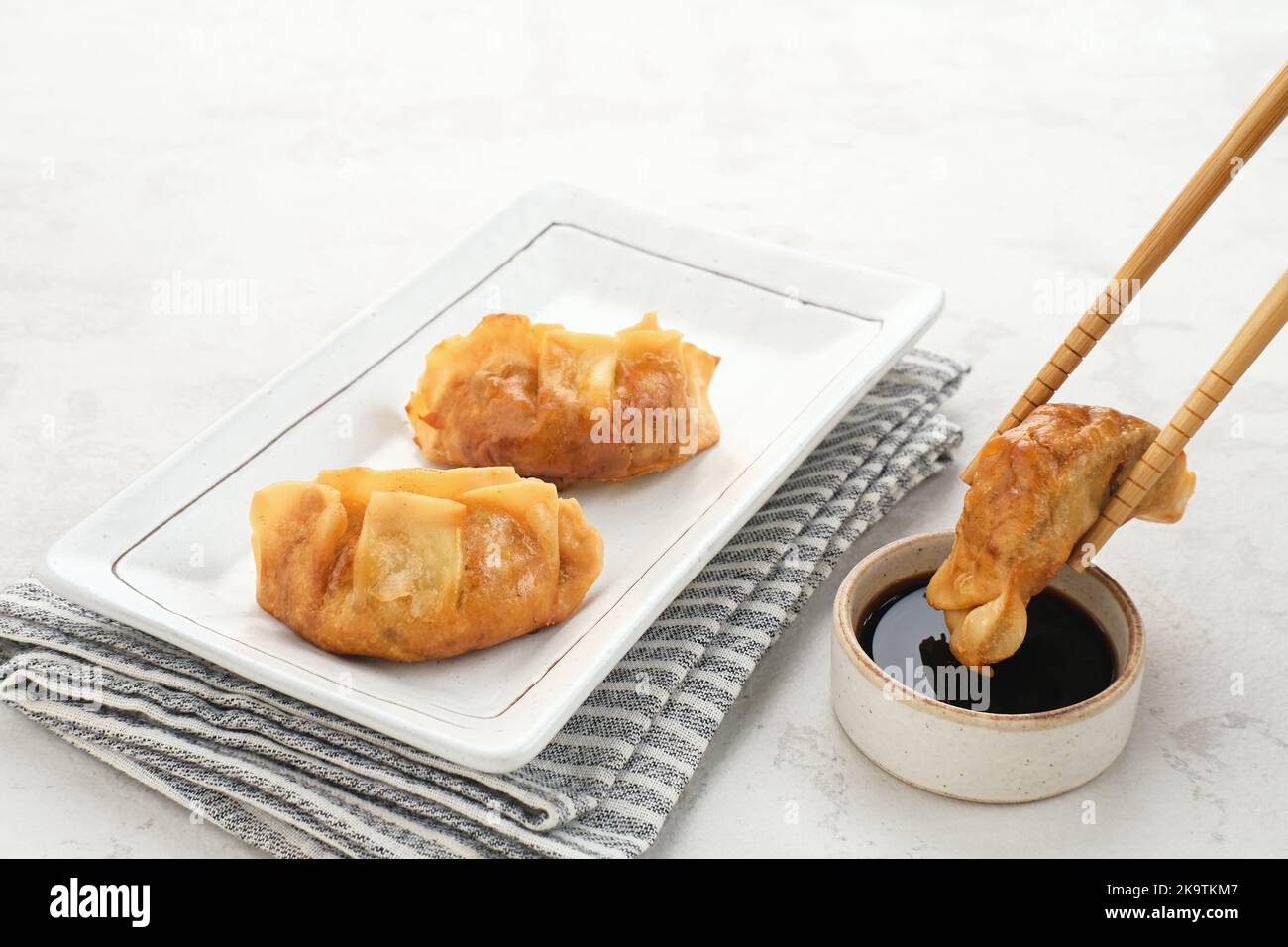 Gyoza, gnocchi fritti con pollo succoso e cavolo. Servito in piatto bianco con salsa di soia Foto Stock