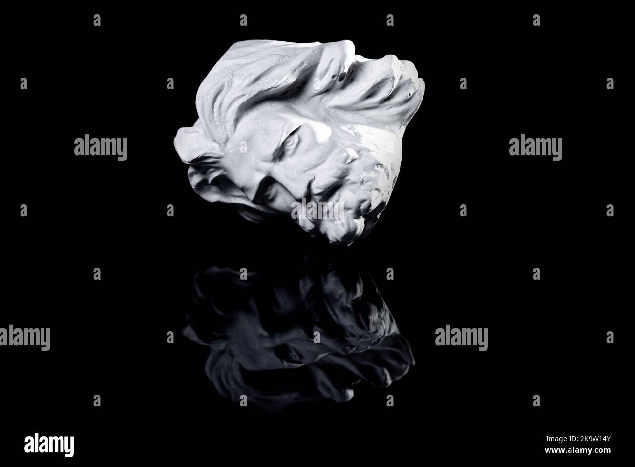 Copia in gesso della famosa statua antica Poseidone testa isolata su uno sfondo bianco. Intonaco scultura antica volto giovane uomo. Epoca rinascimentale. PORTRA Foto Stock