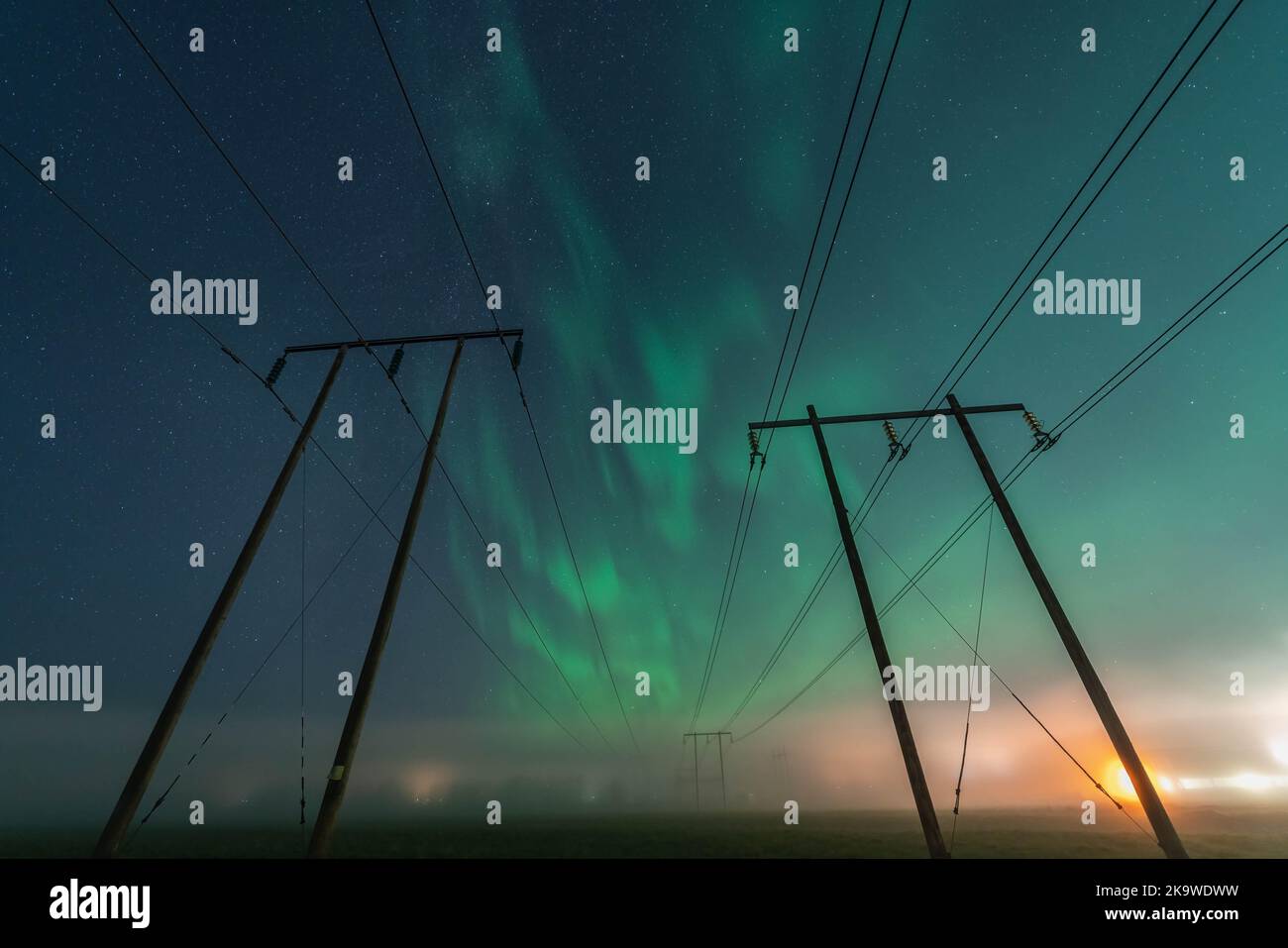 Bella notte Aurora su due linee elettriche a doppio palo in legno in campo autunnale, vista frontale, cielo stellato con Aurora Borealis. Svezia, Umea Foto Stock