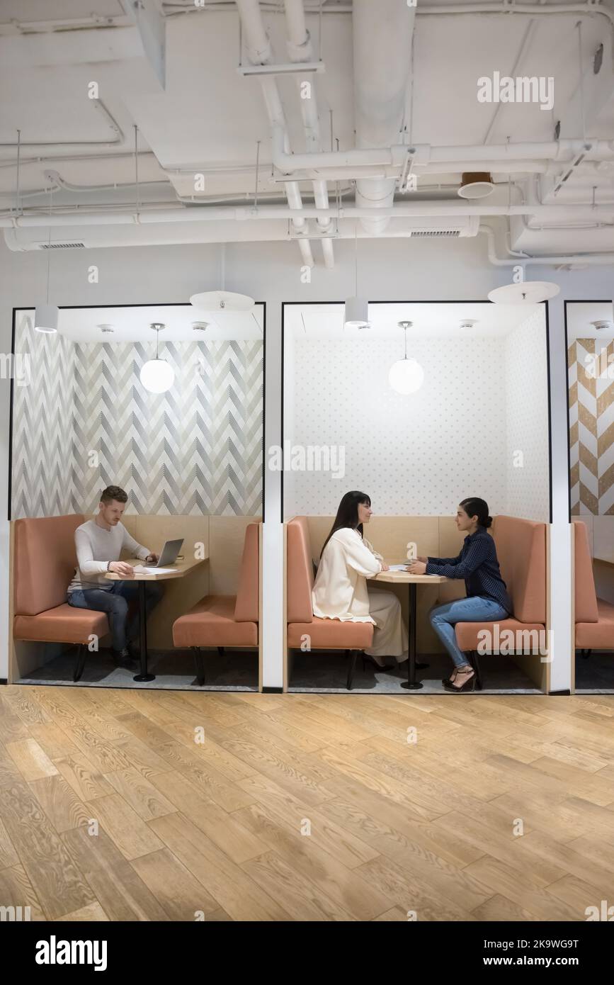 Diversi uomini d'affari che lavorano seduti in un moderno ufficio di coworking Foto Stock