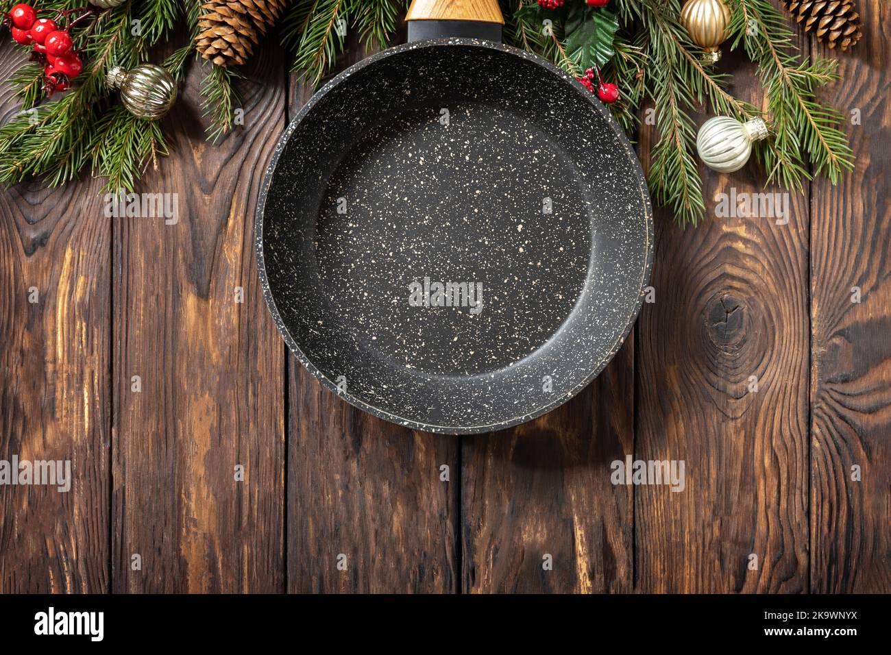 Cucina vuota padella, albero di Natale e decorazioni su sfondo di legno. Design semplice. Vista dall'alto. Spazio di copia. Foto Stock