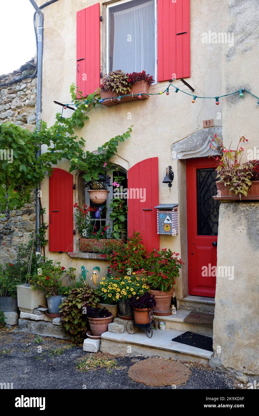 Attraente Village House con persiane rosse e porte nella città vecchia o nel quartiere storico di Dieulefit Drome Francia Foto Stock