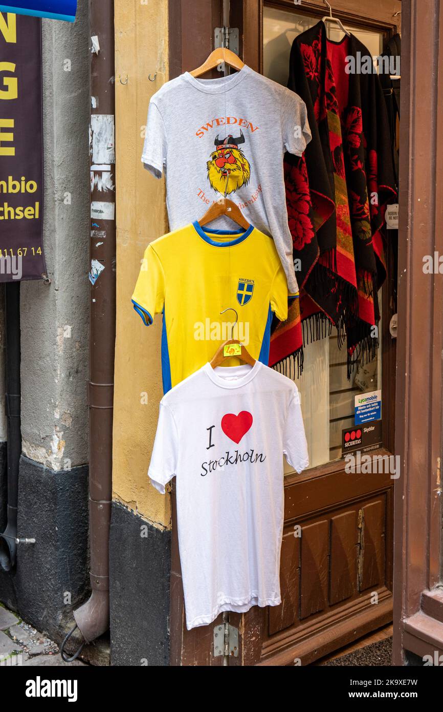 T-shirt ricordo appese di fronte a un negozio di souvenir nella città vecchia di Gamla Stan, Stoccolma, Svezia Foto Stock