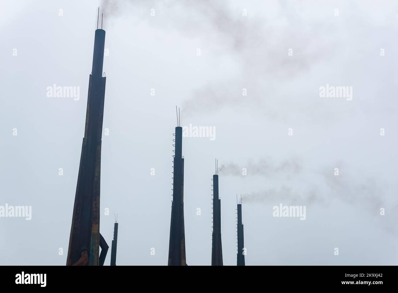 fumo camini di una centrale diesel contro un cielo nuvoloso Foto Stock