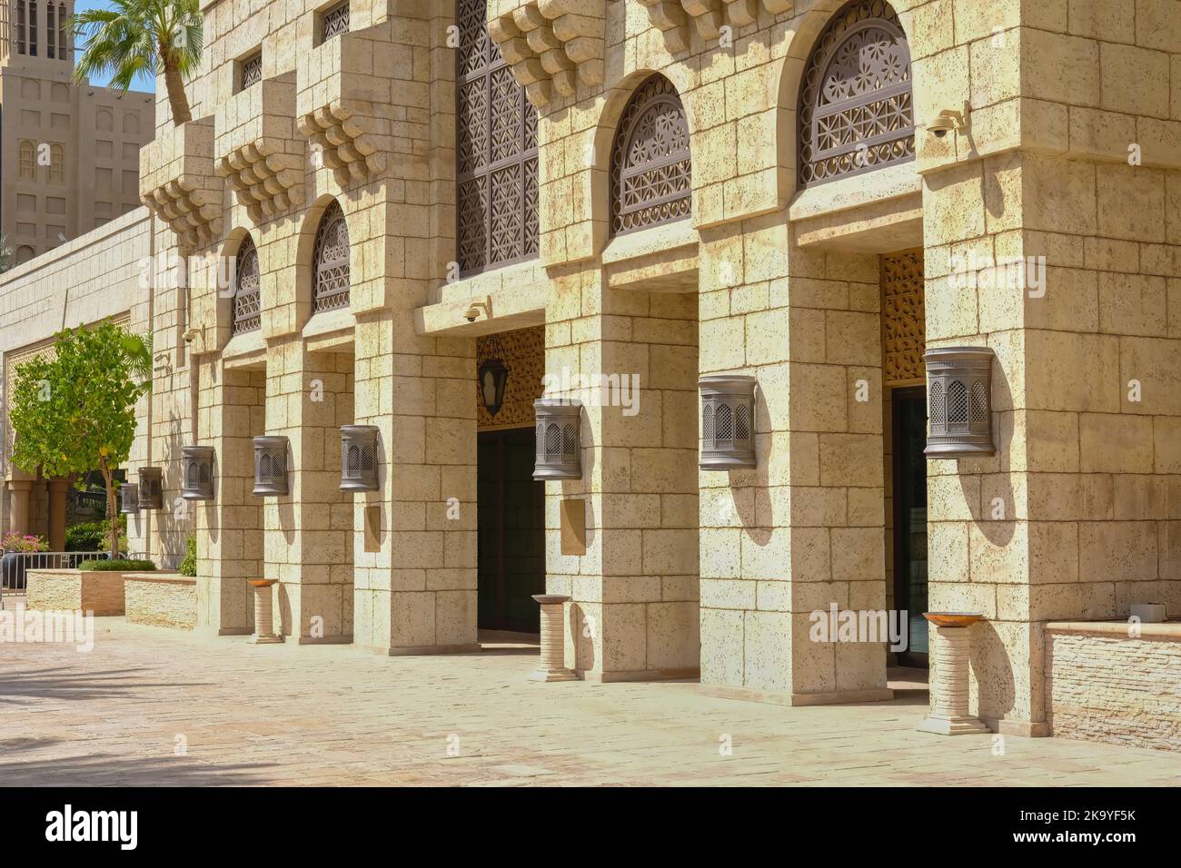 Tipica architettura arabica. Facciata ad arco tradizionale con lanterne in ottone vintage sulla facciata del palazzo della villa Foto Stock