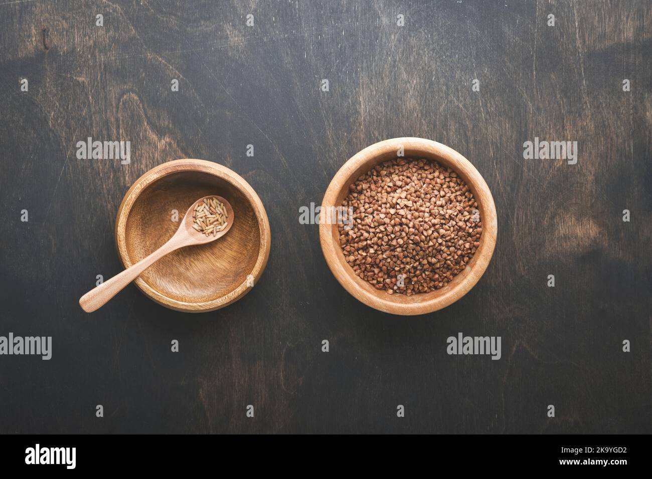 Concetto di crisi alimentare mondiale. Piatto vecchio vuoto e pieno con grano saraceno su sfondo scuro e cupo. Concetto di crisi alimentare globale causata dalla fame a causa di Foto Stock